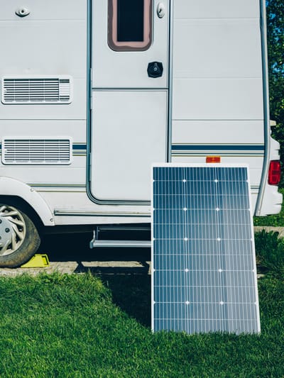 white-rv-caravan-camper-on-a-campsite-with-solar-panel
